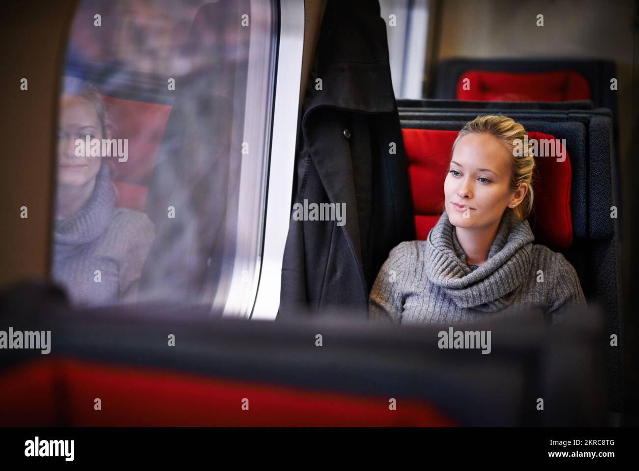 Genießen Sie die friedliche Fahrt. Eine attraktive junge Frau, die mit dem Zug reist. Stockfoto