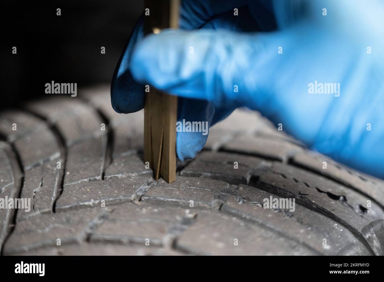 Renningen, Deutschland. 28.. November 2022. Ein Mitarbeiter in einer Werkstatt misst die Lauffläche der Reifen während der Wartung eines Elektroautos des Mazda MX-30. Kredit: Marijan Murat/dpa/Alamy Live News Stockfoto