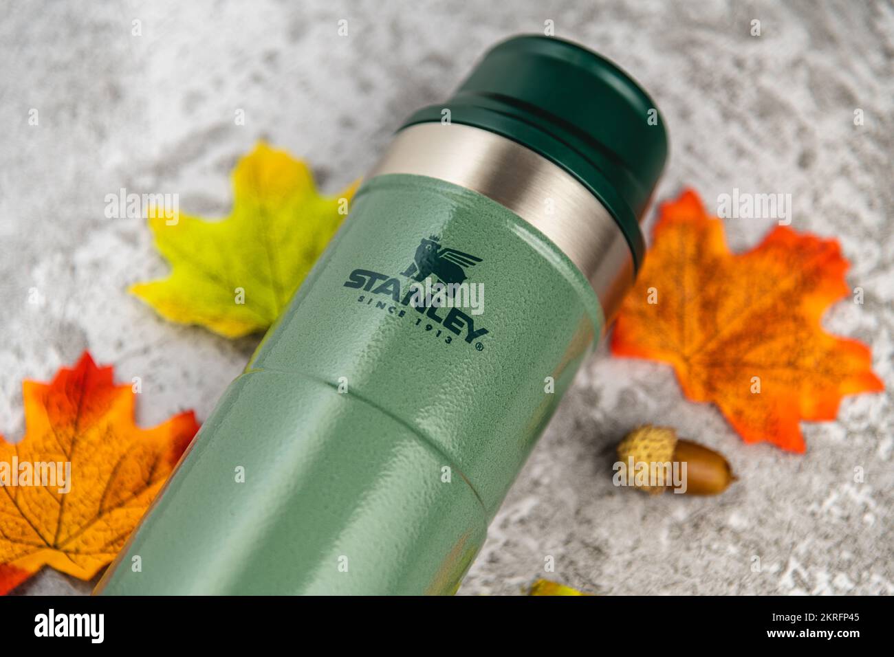 Antalya, Türkei - 28. November 2022: Stanley Action Trigger Thermosbecher mit Blättern in Herbstfarben auf Steinhintergrund Stockfoto