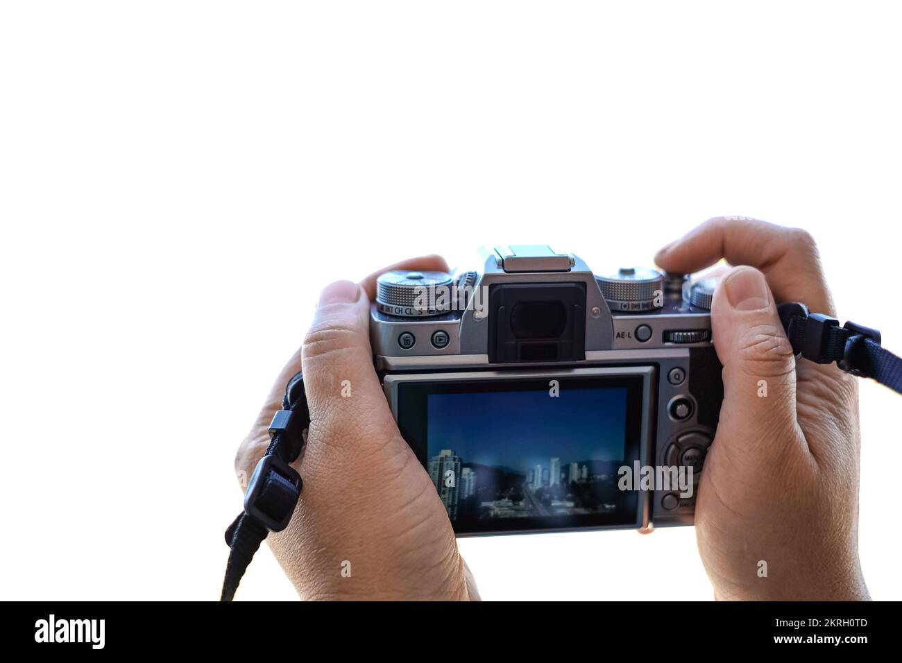 Fotograf, der Fotos mit einer Fotokamera macht. Spiegellose Kamera in den Händen von Touristen, die Fotos einer isolierten Stadt auf weißem Hintergrund mit Kopie macht Stockfoto