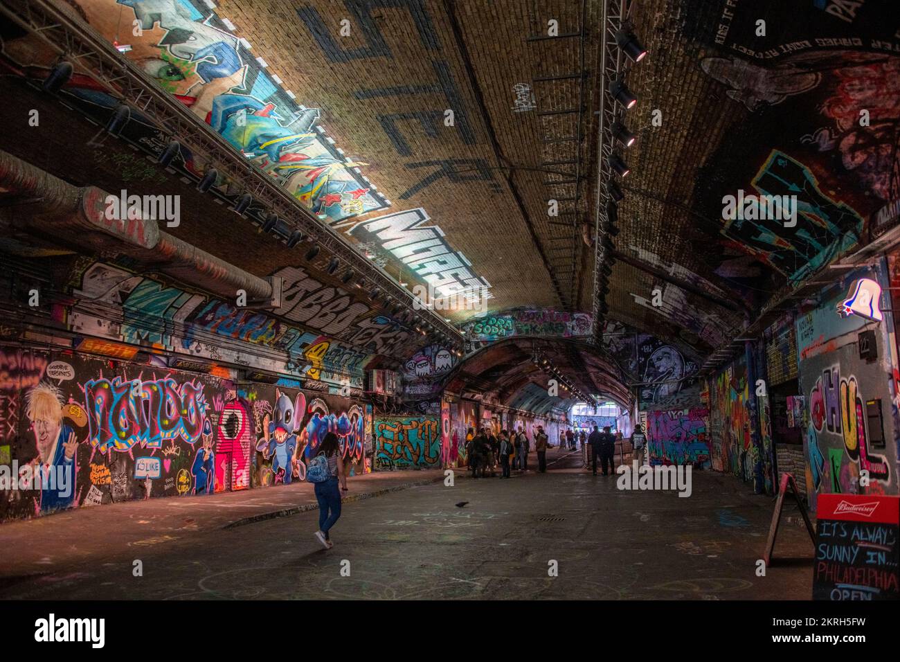 Schöner öffentlicher Ort, um Freunde im Tunnel zu treffen, der mit Graffitis in verschiedenen Farben bemalt ist Stockfoto