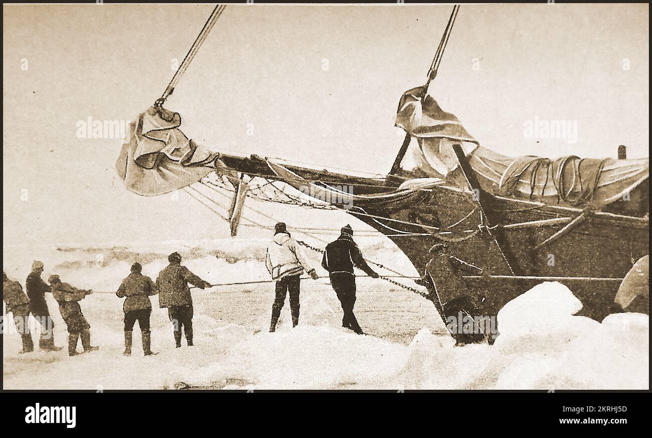 Ein Team aus 1930er Crewmitgliedern, die ein Segelschiff durch Packeis in der Arktis schleppen. Stockfoto