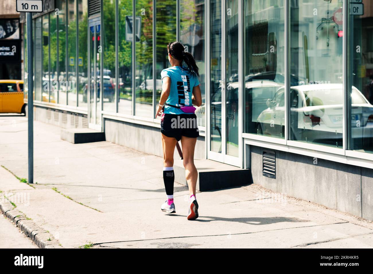 Eine Frau, die auf der Straße der Stadt läuft Stockfoto
