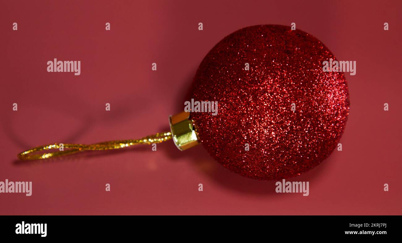 Roter weihnachtsball, Kugel isoliert auf rotem Hintergrund. Weihnachtsdekoration. Flach verlegt. Speicherplatz kopieren. Draufsicht. Stockfoto