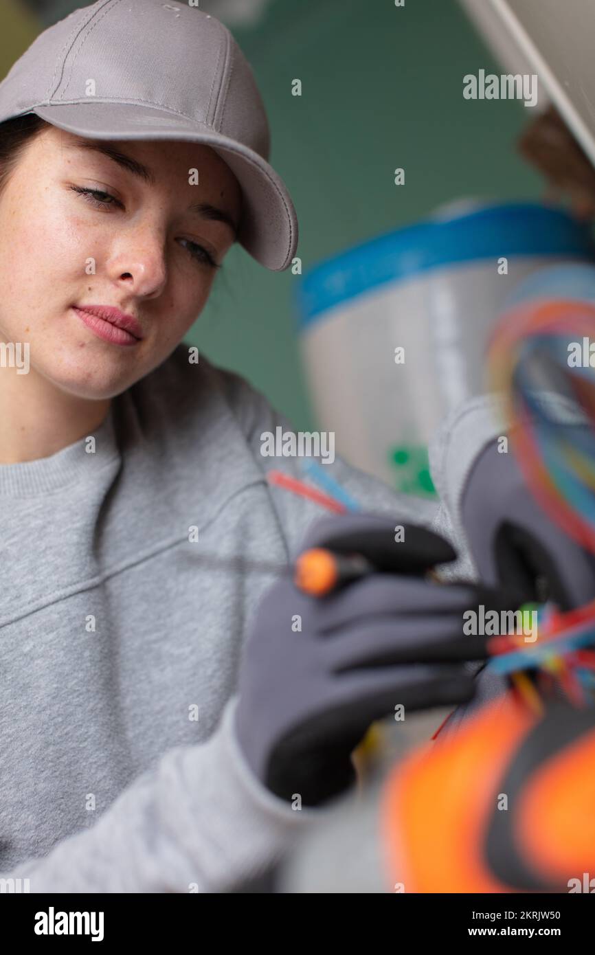 Weibliche Elektriker Arbeiten an der Verkabelung Stockfoto