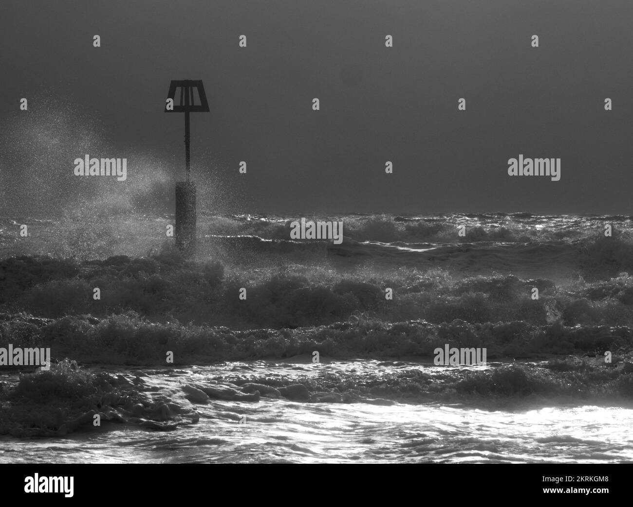 Winterwellen, die gegen die Groyne-Markierungen am Boscombe Beach, Bournemouth, spritzen Stockfoto