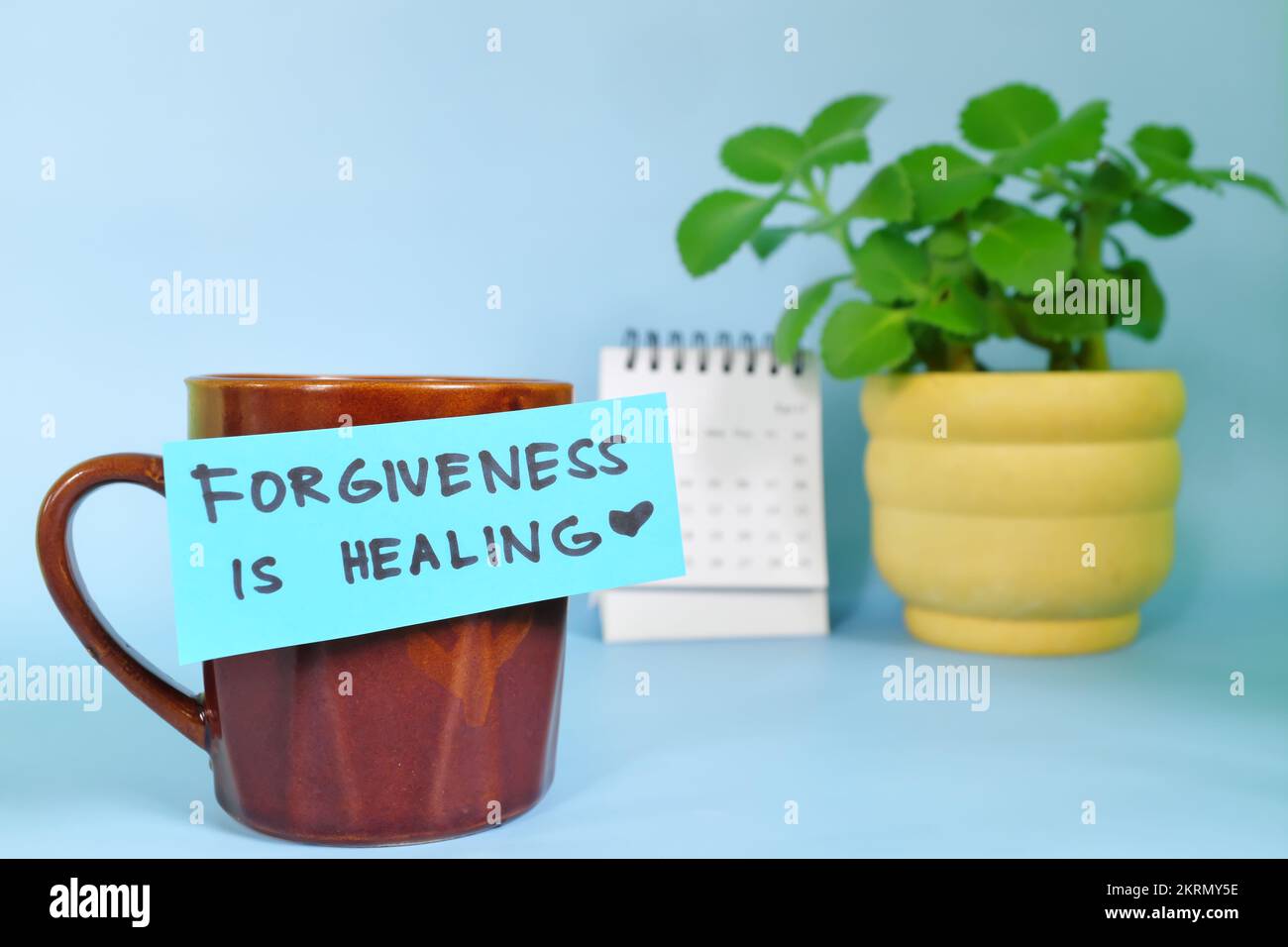 Vergebung ist heilende Motivation und Inspiration Botschaft Konzept. Selektiver Fokus einer Tasse Kaffee mit handgeschriebener heller Papiernote. Stockfoto