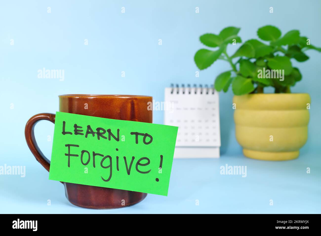 Lerne, Motivation und Inspiration zu verzeihen. Selektiver Fokus einer Tasse Kaffee mit handgeschriebener heller Papiernote. Stockfoto