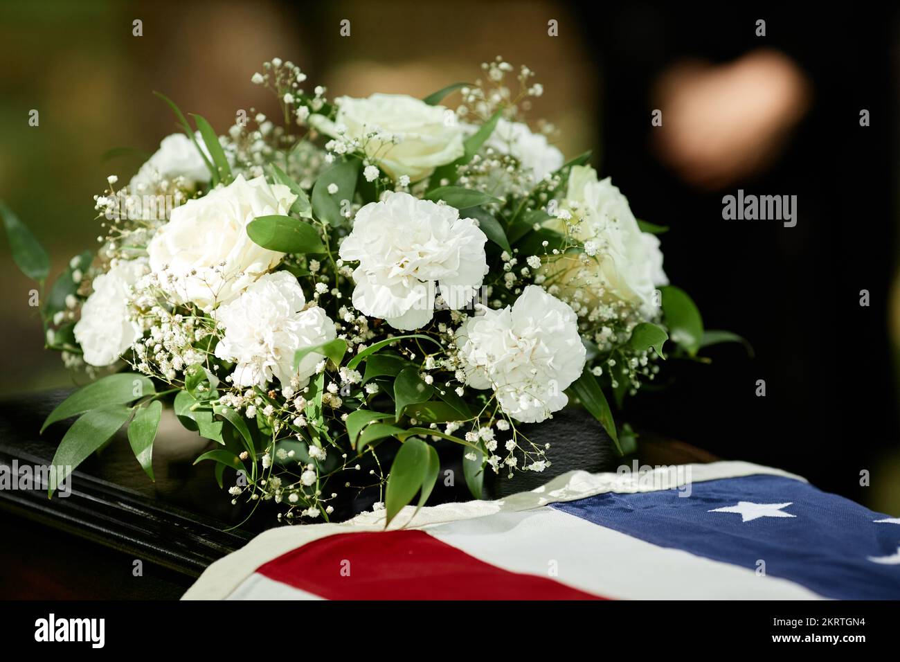 Nahaufnahme der amerikanischen Flagge auf dem Sarg mit Blumen bei der Beerdigung im Freien für Militärveteran, Kopierraum Stockfoto