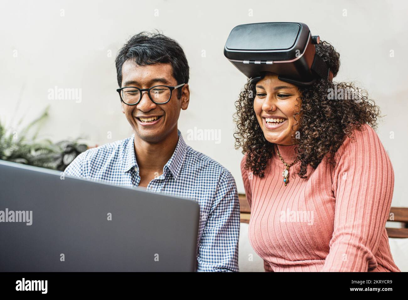 Junge Menschen der Z-Generation, die Augmented Reality verwenden, zwei birassische Personen, die auf dem Laptop-Bildschirm Erfahrungen in der virtuellen Realität und im Metaversum sammeln Stockfoto