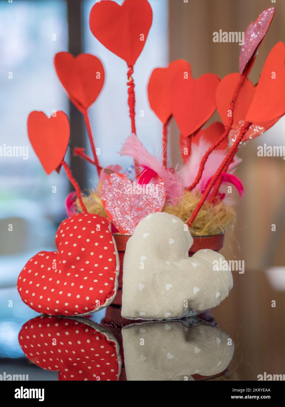 Ein rotes Herz spiegelt sich am Valentinstag im Klavier wider. Stockfoto