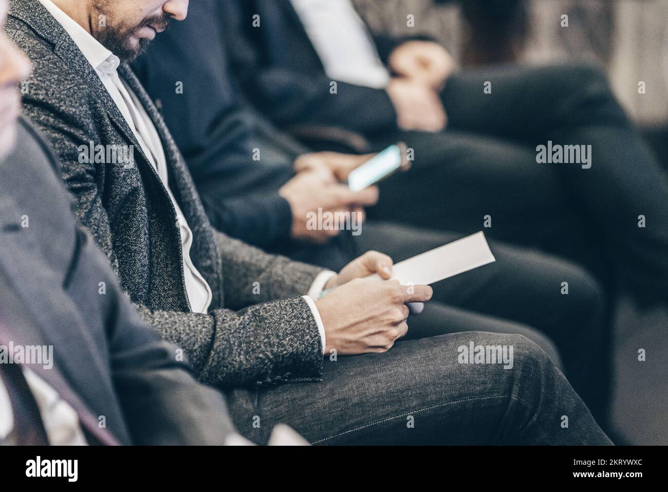 Geschäftsleute halten eine Broschüre mit Programm und Terminen für Vorträge zu Geschäftskonferenzen. Veranstaltungsteilnehmer im Konferenzsaal Stockfoto