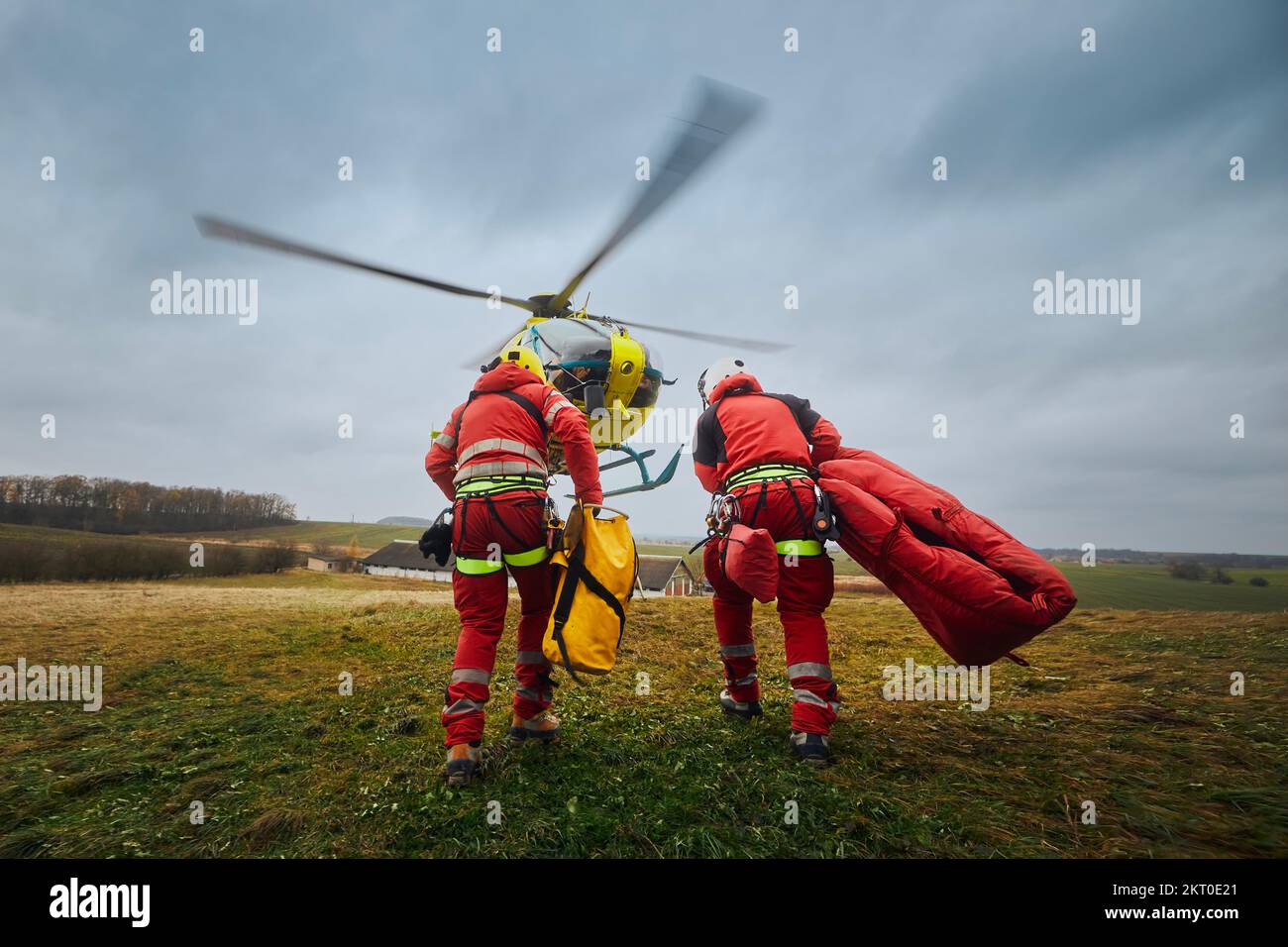 Zwei Sanitäter mit Auffanggurt und Kletterausrüstung, die zum Helikopter Rettungsdienst fahren. Die Themen Rettung, Hilfe und Hoffnung. . Stockfoto