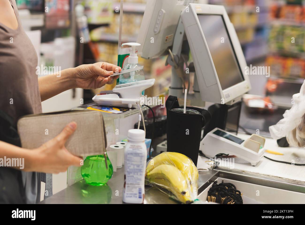 Weibliche Kundin, die im Einkaufszentrum per Kreditkarte mit NFC-Technologie bezahlt. Stockfoto