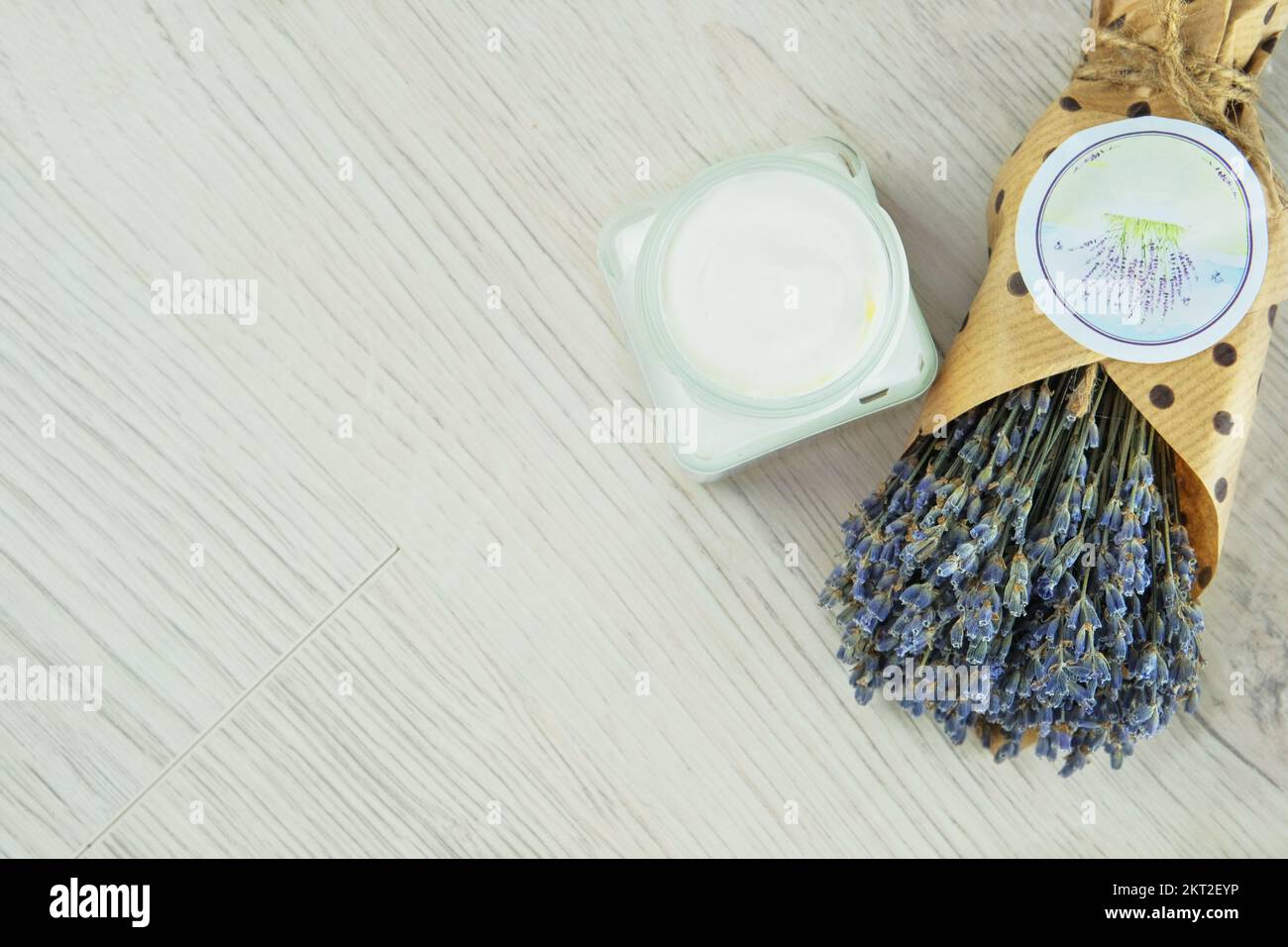 Handgefertigte kosmetische Cremebecher und getrocknete Lavendelblumen auf hellem Hintergrund. Bio-organische Kosmetik. Pflanzenbasis. Stockfoto