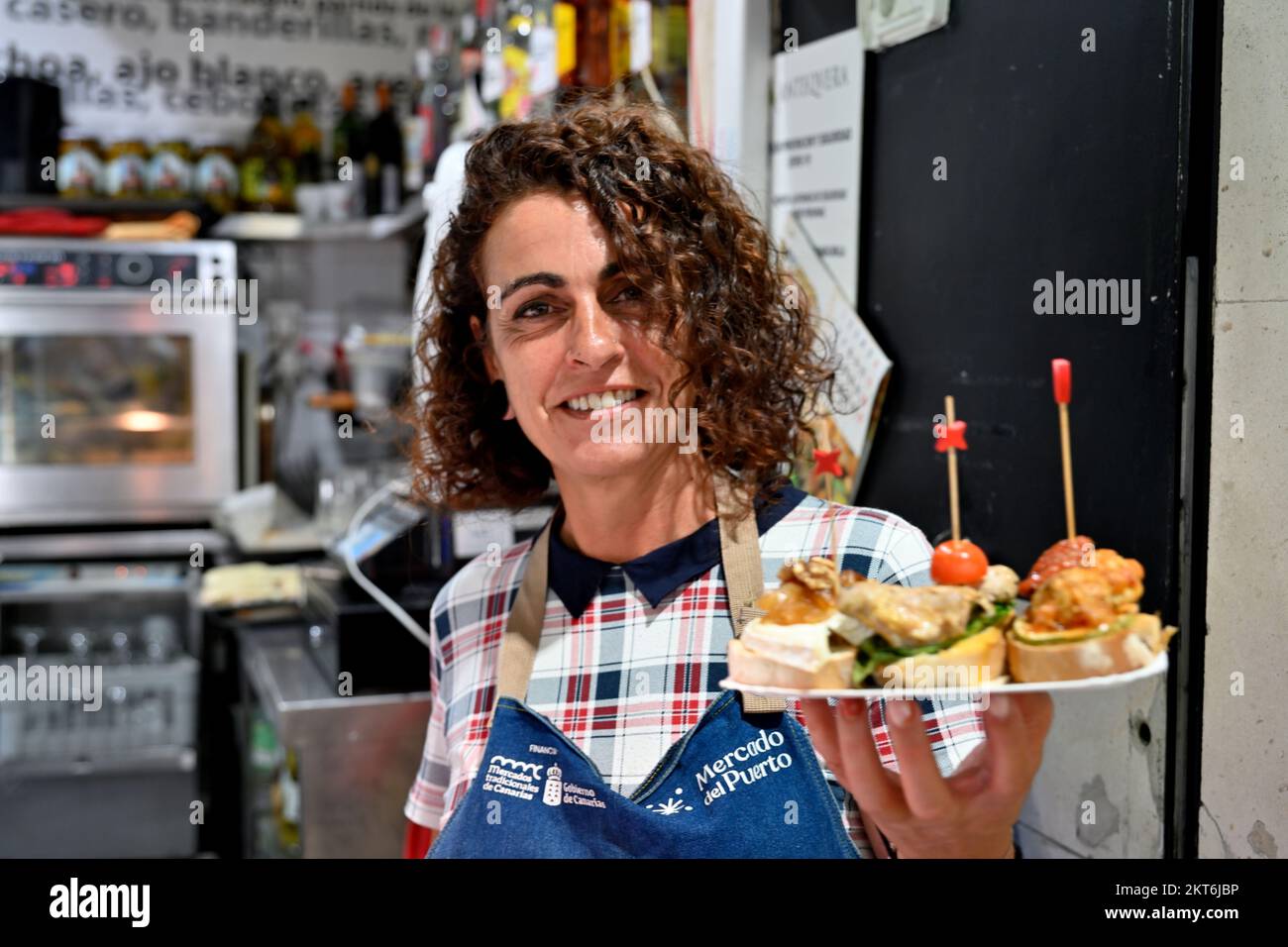 Eine servierende Frau hielt einen Teller „Pinchos“, traditionelle kleine Snacks im Tapas-Café Stockfoto