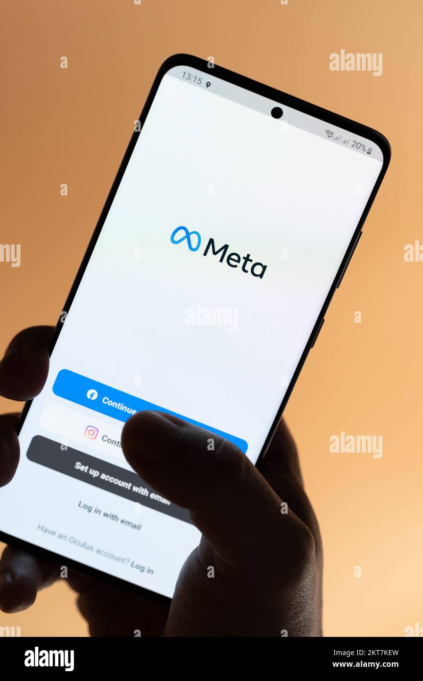 New york, USA - 4. November 2022: Verwendung der Meta-App auf einem Smartphone, das auf braunem Hintergrund isoliert in der Hand gehalten wird Stockfoto