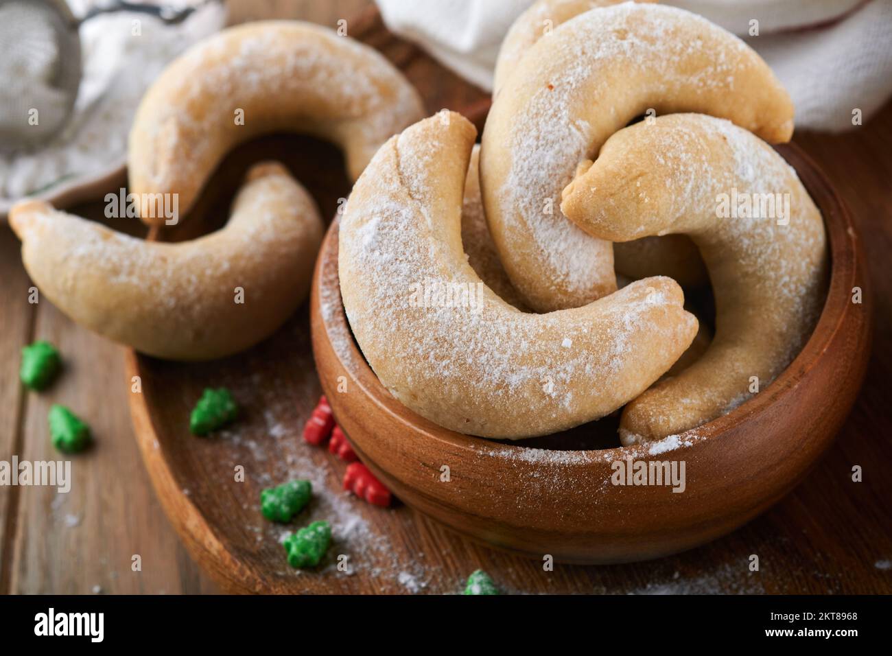 Weihnachtsplätzchen Crescents. Hausgemachte traditionelle Weihnachtskekse Vanillekies in rustikalem Teller mit weihnachtsdekorationen auf altem Holz rustikal Stockfoto