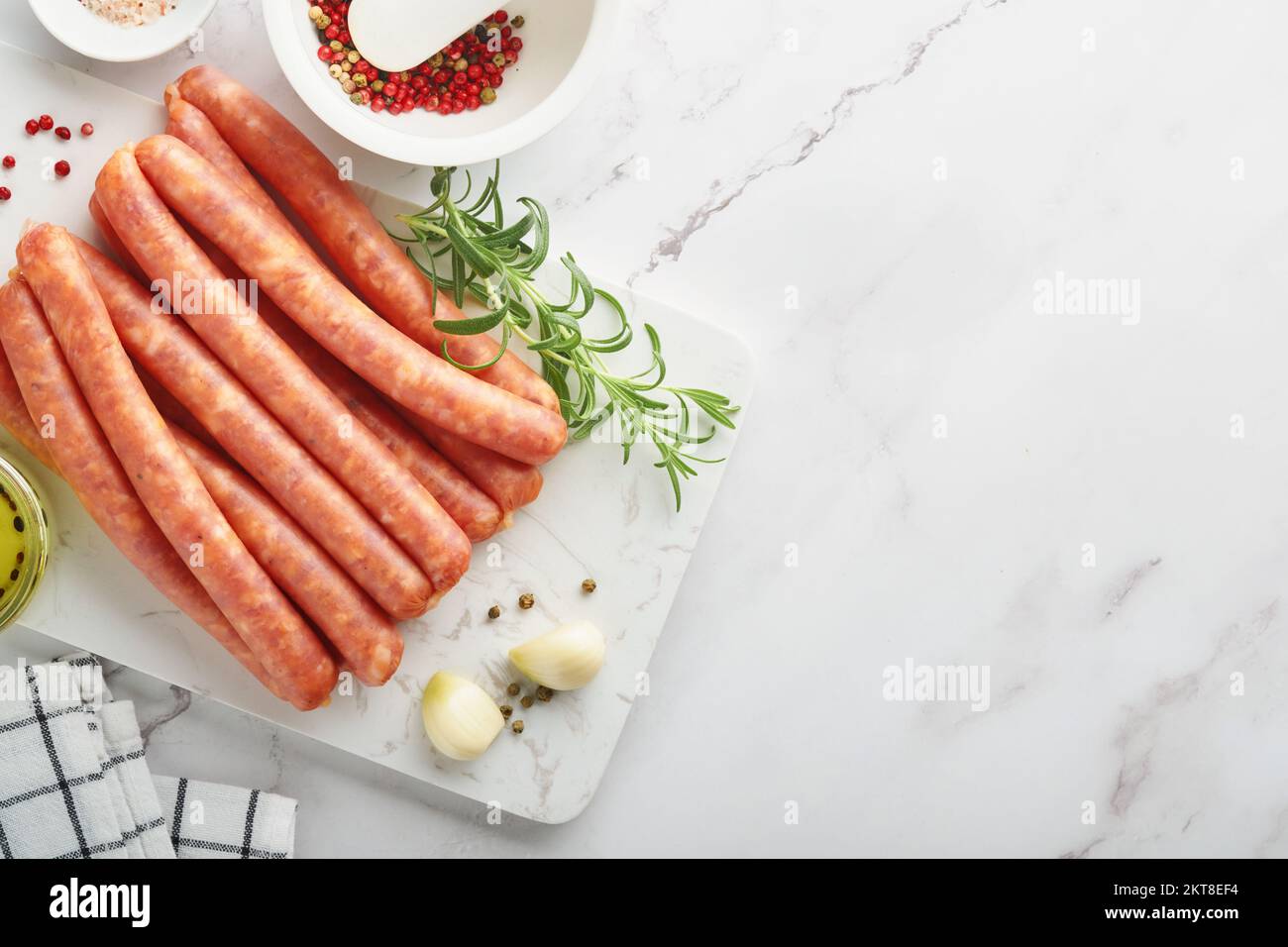 Fleischwurst. Rohe Barbecue-Würste mit Gewürzen, Gemüse und Zutaten zum Kochen auf weißem Hintergrund. Draufsicht. Speicherplatz kopieren. Oktoberfest m Stockfoto