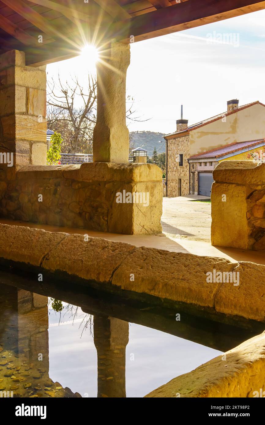 Sonne spiegelte sich im Wasser eines alten öffentlichen Waschraums, um Kleidung auf dem Platz, Spanien, zu waschen. Stockfoto