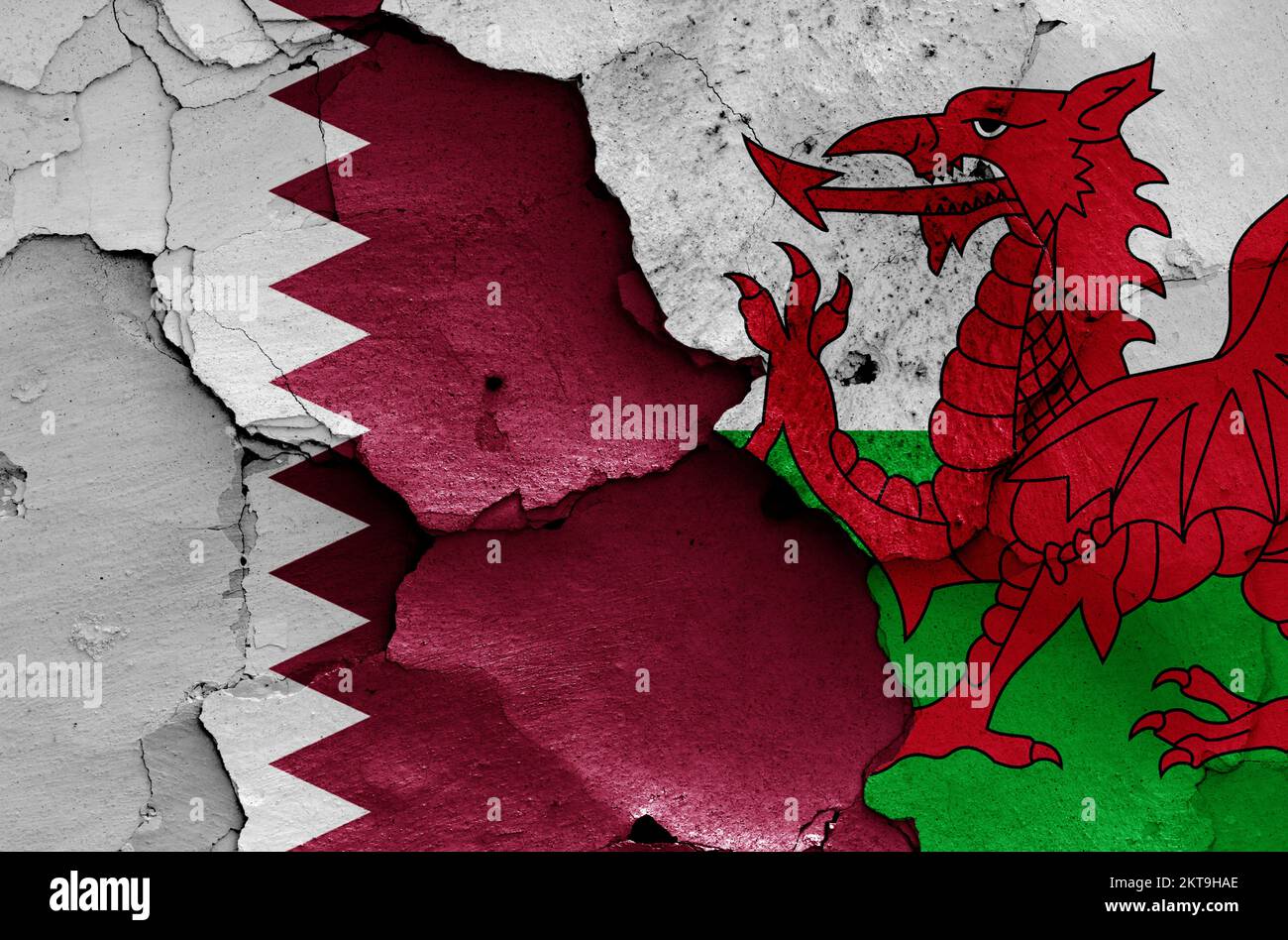 Flaggen von Katar und Wales, gemalt an einer gerissenen Wand Stockfoto