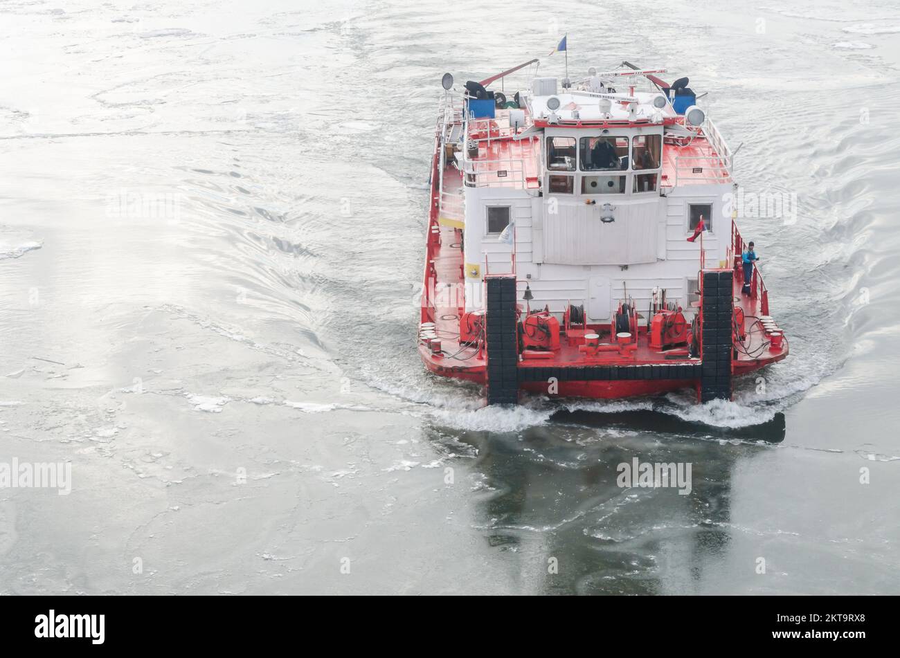 Die Donau ist mit Schnee und Eis bedeckt. Ein Eisbrecherschiff in der gefrorenen und schneebedeckten Donau unterhalb der Festung Petrovaradin Stockfoto