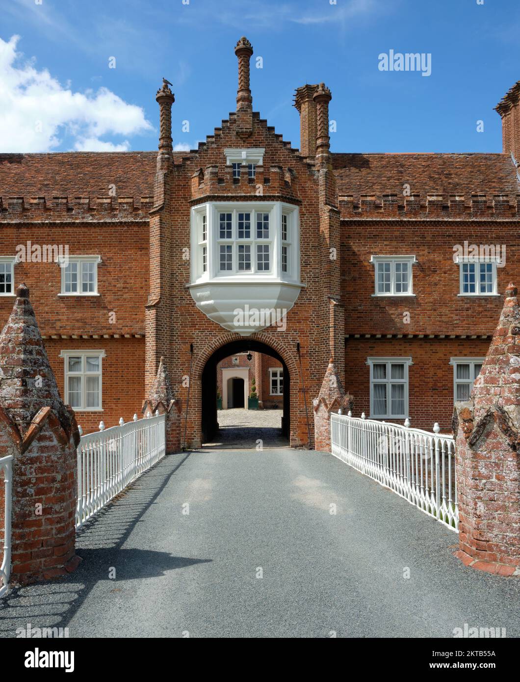 Sommerblick auf die Helmingham Hall über die Zugbrücke mit Blick auf das Porträt am blauen Himmel Stockfoto