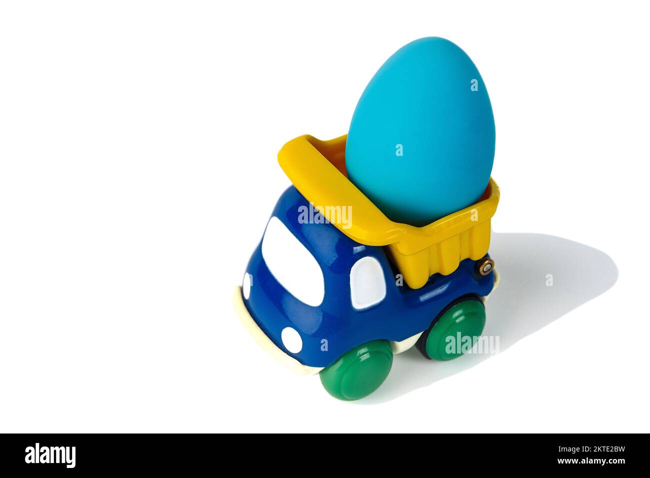 Ein Spielzeug-Kipplaster für Kinder transportiert ein Ostergeschenkei Stockfoto