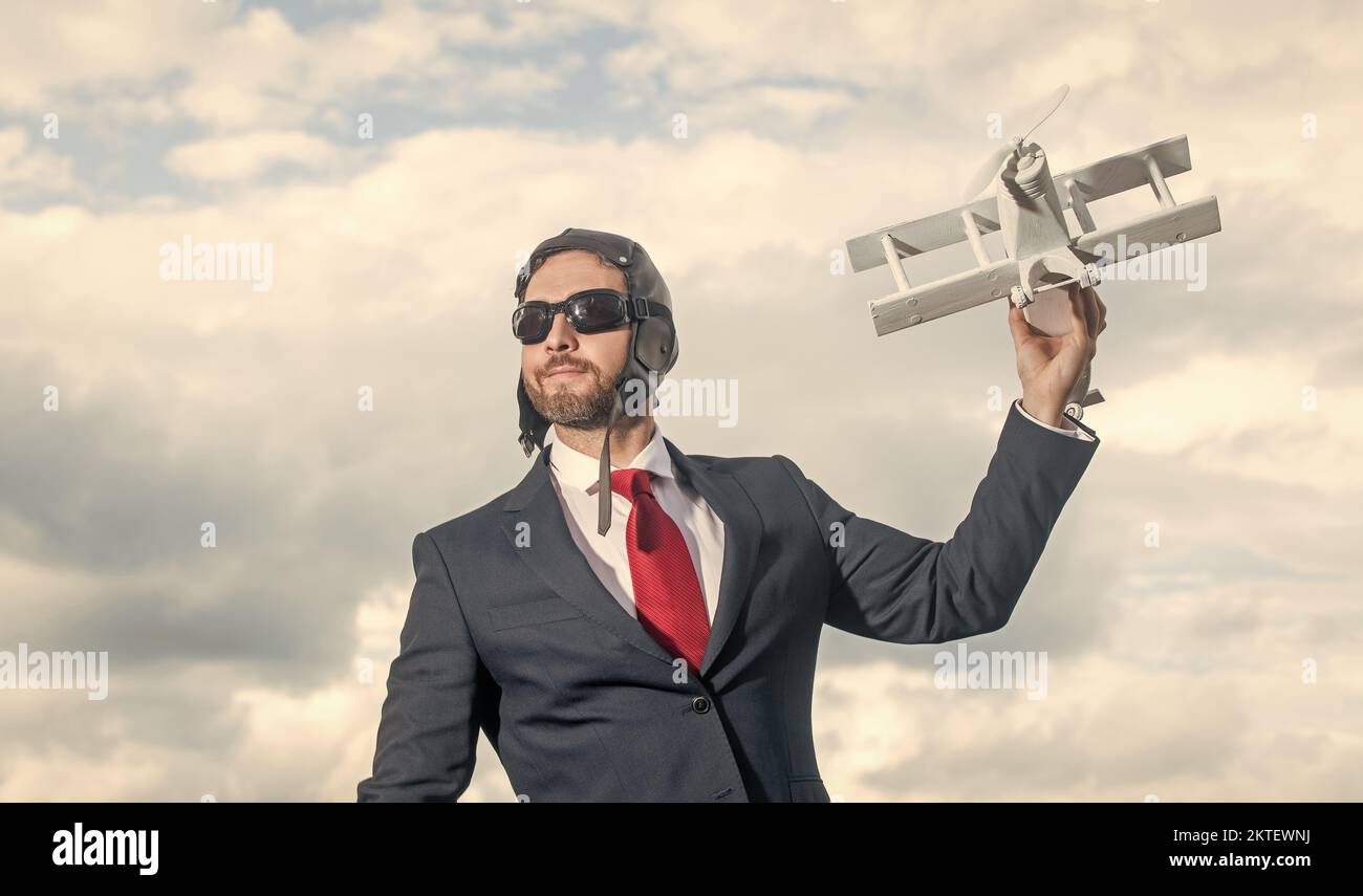 Geschäftsmann in Anzug und Pilot Hut Launch Flugzeug Spielzeug. Leistung Stockfoto