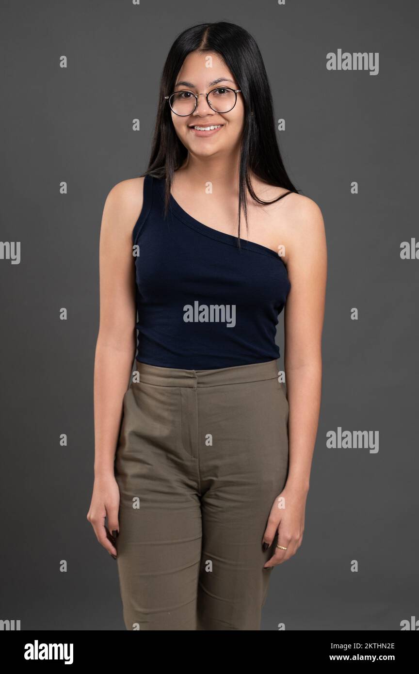 Porträt eines hispanischen jungen Mädchens mit Sonnenbrille auf grauem Studiohintergrund Stockfoto
