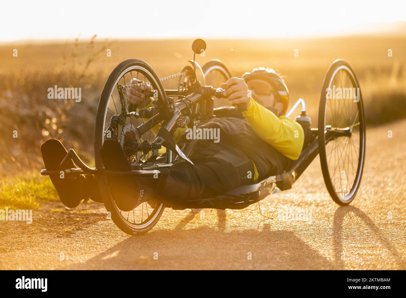 Malerische Aufnahme eines jungen Sportlers mit Behinderung auf einem Handrad. Adaptives Training bei Sonnenuntergang im Freien. Hochwertige Fotografie. Stockfoto