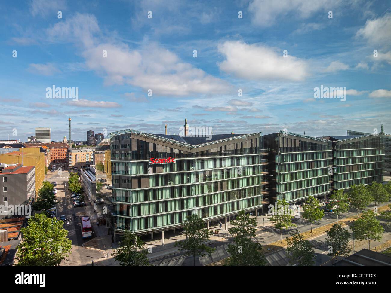 Kopenhagen, Dänemark - 24. Juli 2022: Lerge Scandic Spectrum Hotel Gebäude in der Kalvebod Brygge Straße unter blauer Wolkenlandschaft mit Stadtbild hinten. Tiv Stockfoto