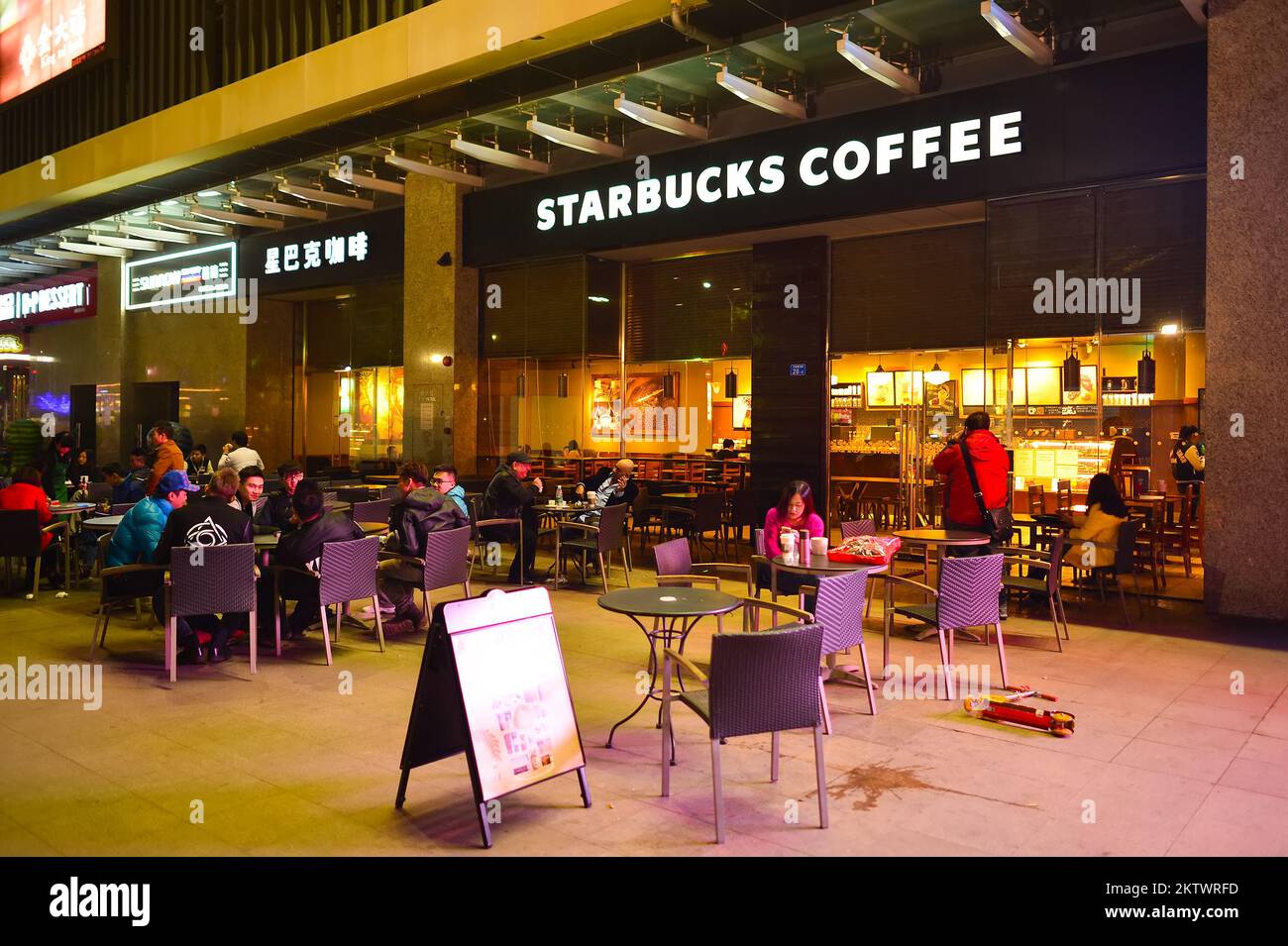 SHENZHEN, CHINA - 22. JANUAR 2015: Starbucks Café bei Nacht. Die Starbucks Corporation ist ein amerikanisches globales Kaffeeunternehmen und eine Kaffeehauskette mit Sitz in Stockfoto