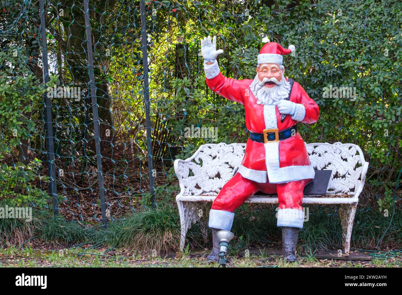 In New Orleans, Louisiana, USA, stehen und schwenken die Weihnachtsmann-Figur und die weiße Bank Stockfoto