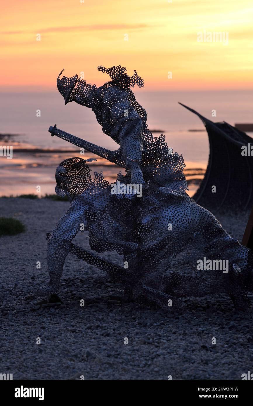 Lebensgroße Skulpturenfigur im D-Day 75 Garden in Arromanches-les-Bains, Frankreich bei Sonnenuntergang. Die Installation wurde zunächst von John Everiss für erstellt Stockfoto