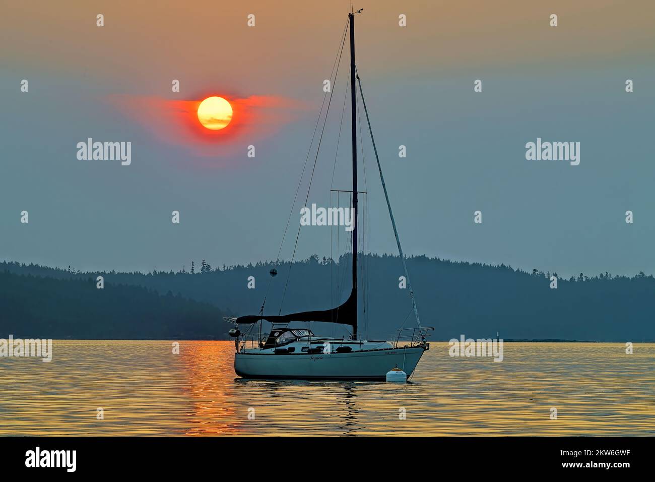 Ein Segelboot, das vor der Küste von Vancouver Island unter einem rauchgefüllten Himmel von den Waldbränden in British Columbia festgemacht wurde Stockfoto