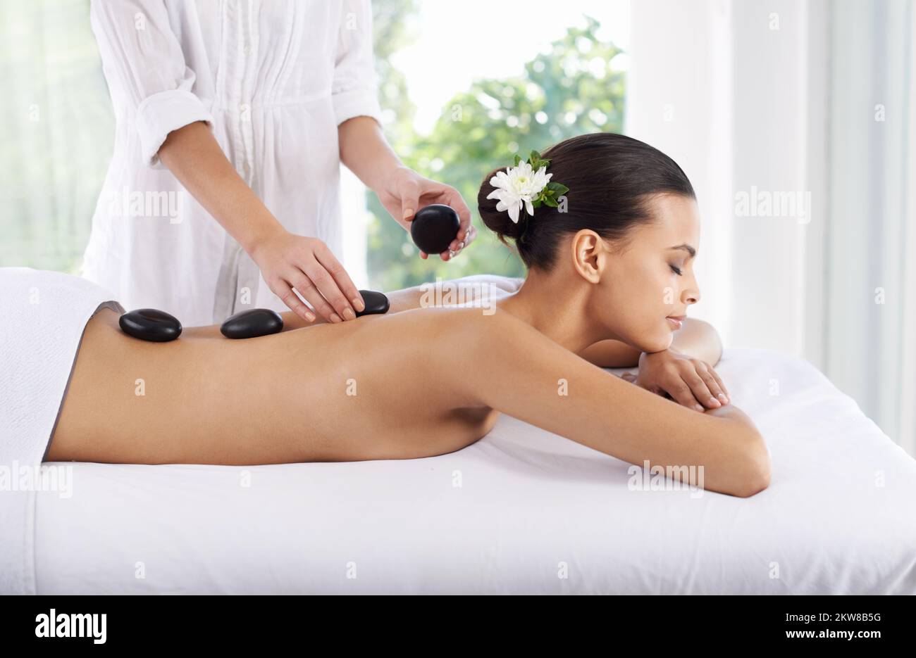 Heilung heißer Steine. Eine junge Frau, die eine Hot-Stone-Massage bekommt. Stockfoto