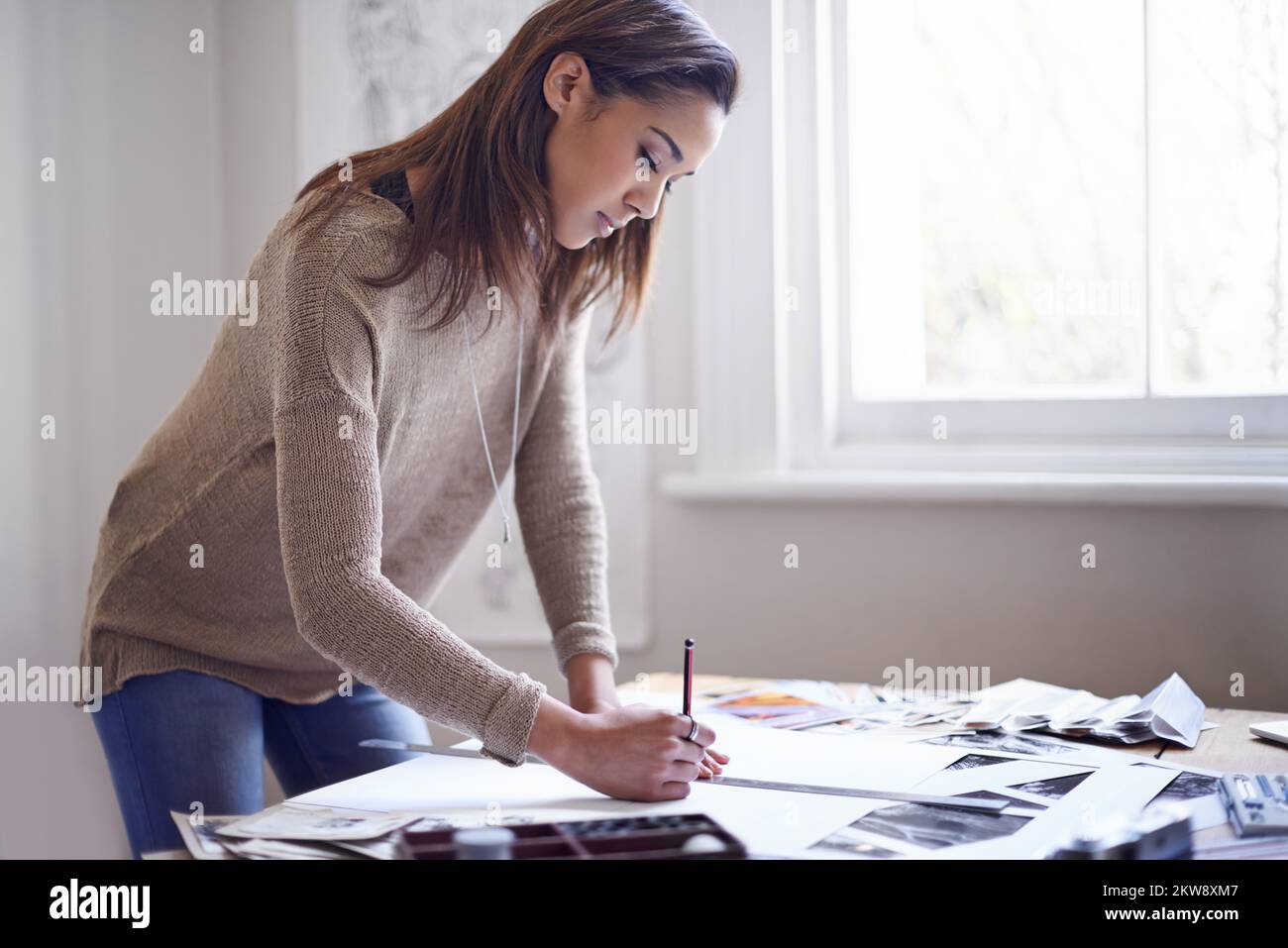 Das perfekte Portfolio. Eine junge Frau, die zu Hause an ihrem Portfolio arbeitet. Stockfoto