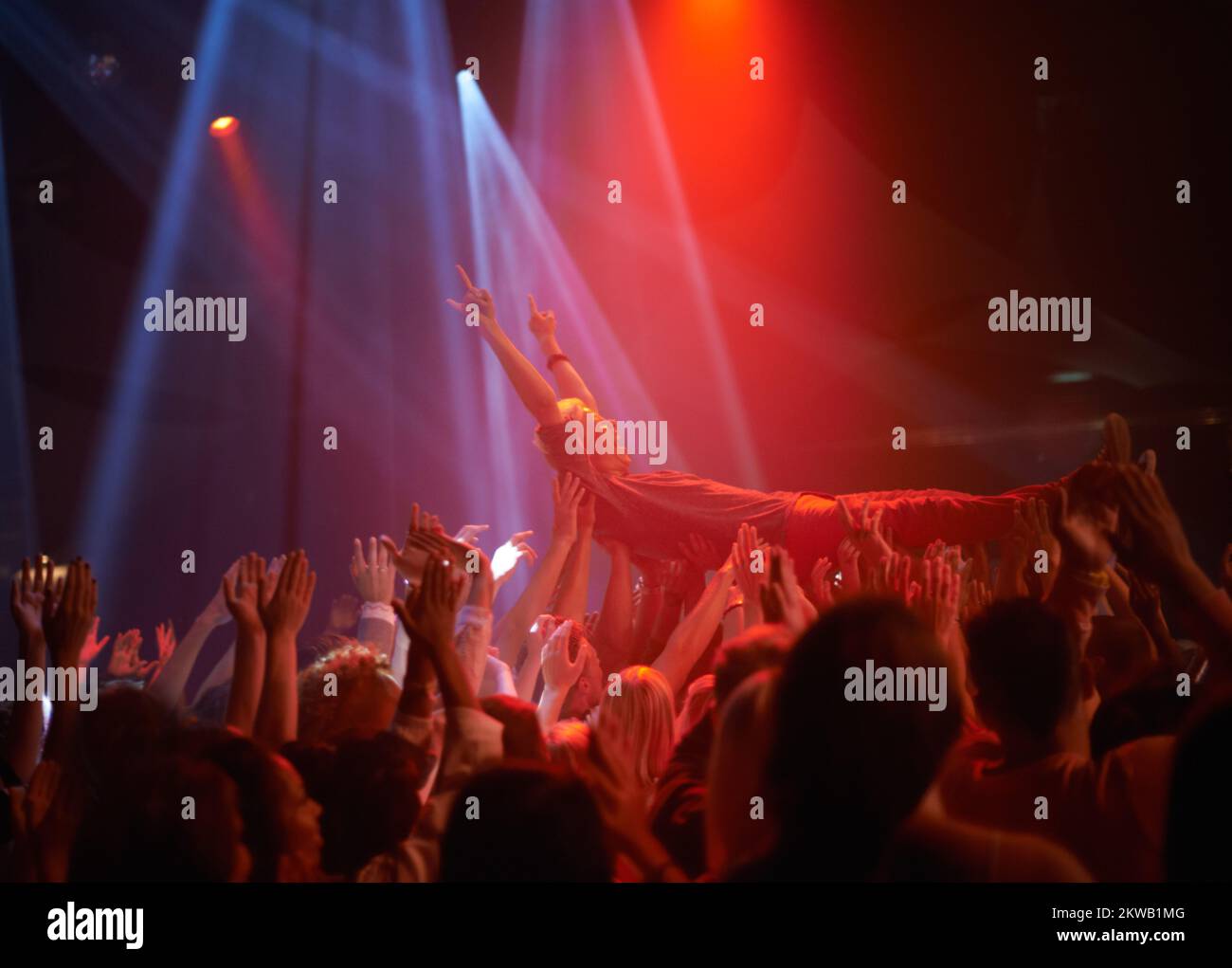 Surfen in einer Menge von Fans. Ein Bühnentaucher, der auf einem Rockkonzert durch das Publikum getragen wird. Stockfoto