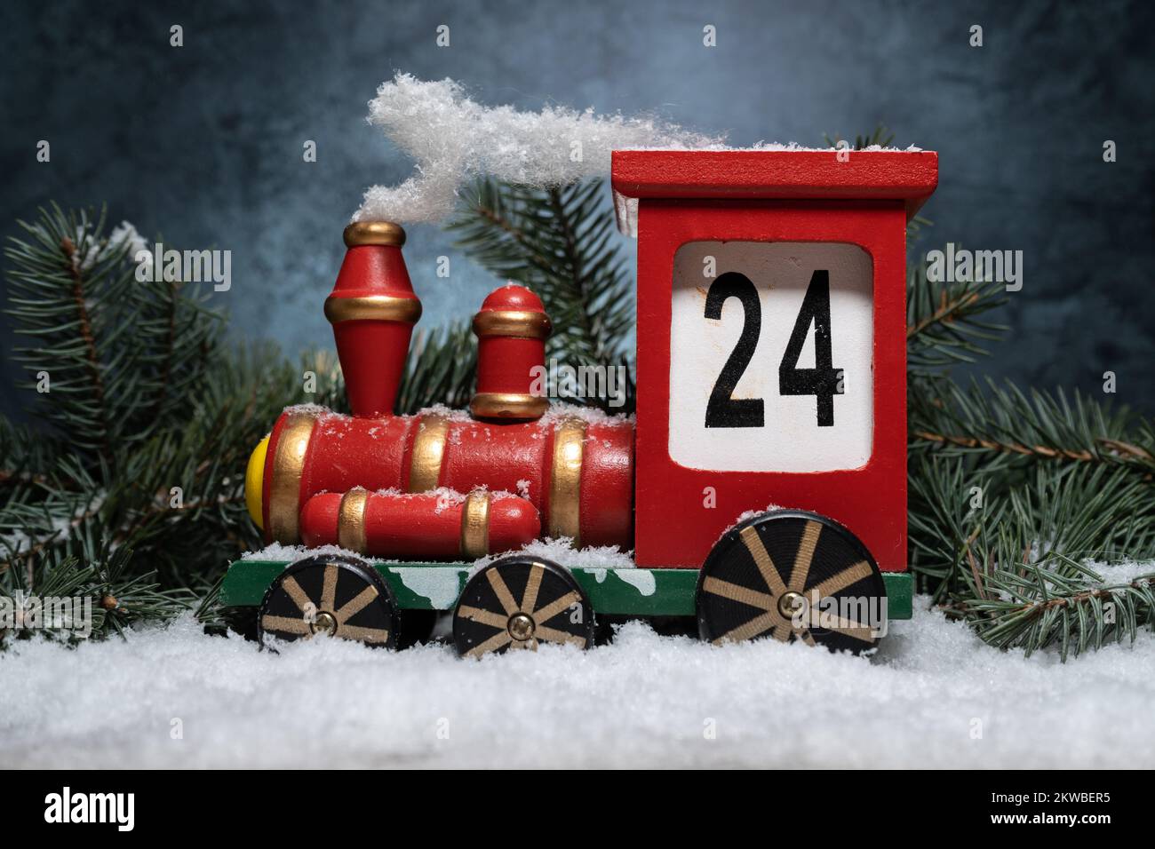 Hölzerner Zug-Adventskalender. Countdown zur Weihnachtsdekoration. Ich zähle die Tage bis Weihnachten herunter. Komposition mit Baumzweigen auf Schnee. Stockfoto