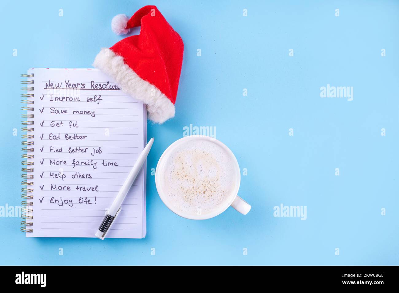 Zielliste für Neujahrsplan auf dem Notizbuch mit Weihnachtsmannmütze, Kaffee Latte oder heiße Schokoladentasse, einfache Neujahrsziele Liste 2023, Planliste für Neujahrsbegi Stockfoto