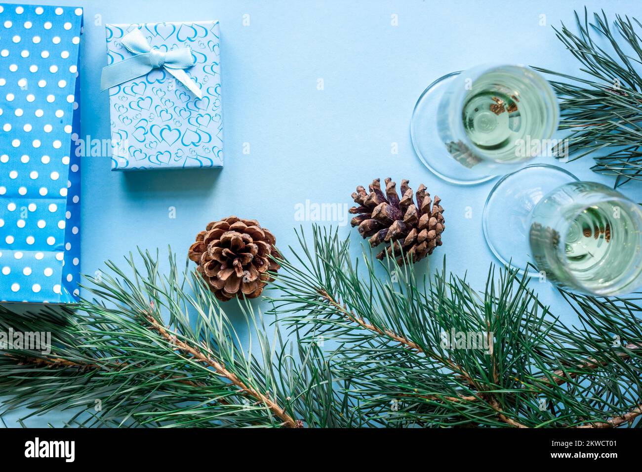 Neujahrsfest mit Fichtenzweigen, Weihnachtsgeschenken und mit einem Paar Weingläser Champagner. Flach liegend, Draufsicht, Kopierbereich Stockfoto