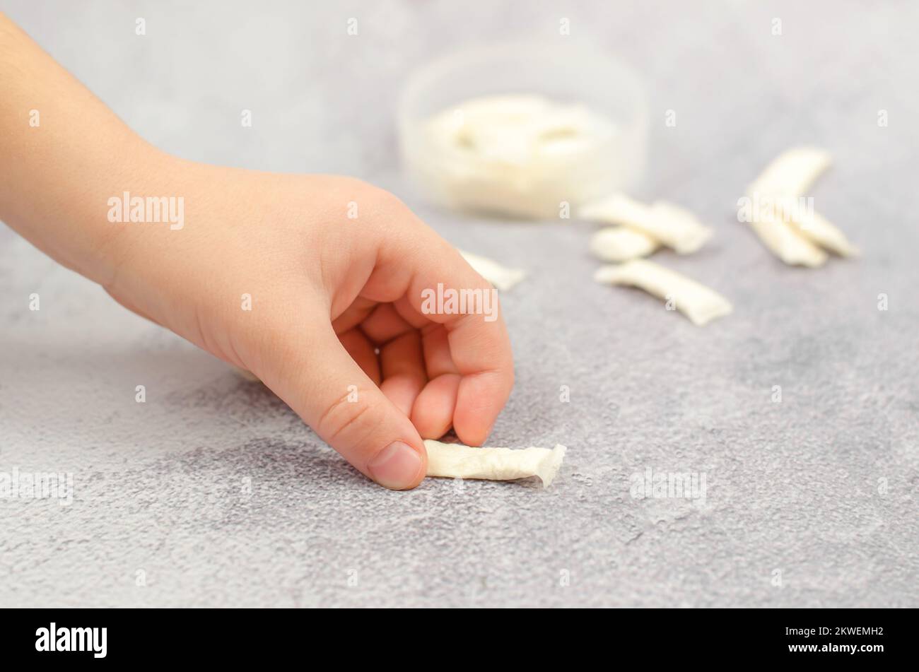 Die Hand eines Kindes nimmt eine Tüte Snus. Suchtbegriff bei Kindern Stockfoto