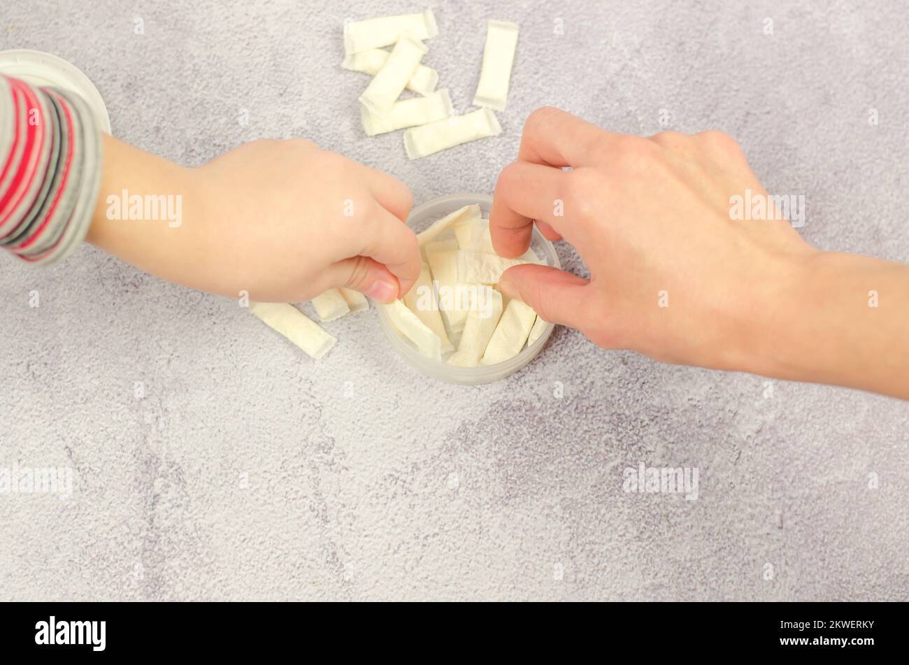 Die Hand von Frau und Kind nimmt schwedischen Snus aus der Schachtel, Nahaufnahme Stockfoto