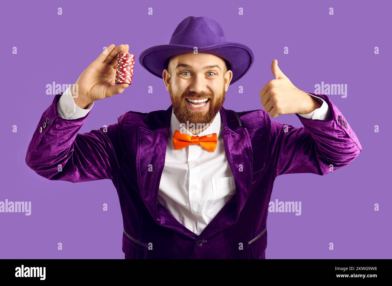 Das Porträt eines lächelnden Mannes, der Casino-Chips hält, zeigt Daumen hoch Stockfoto