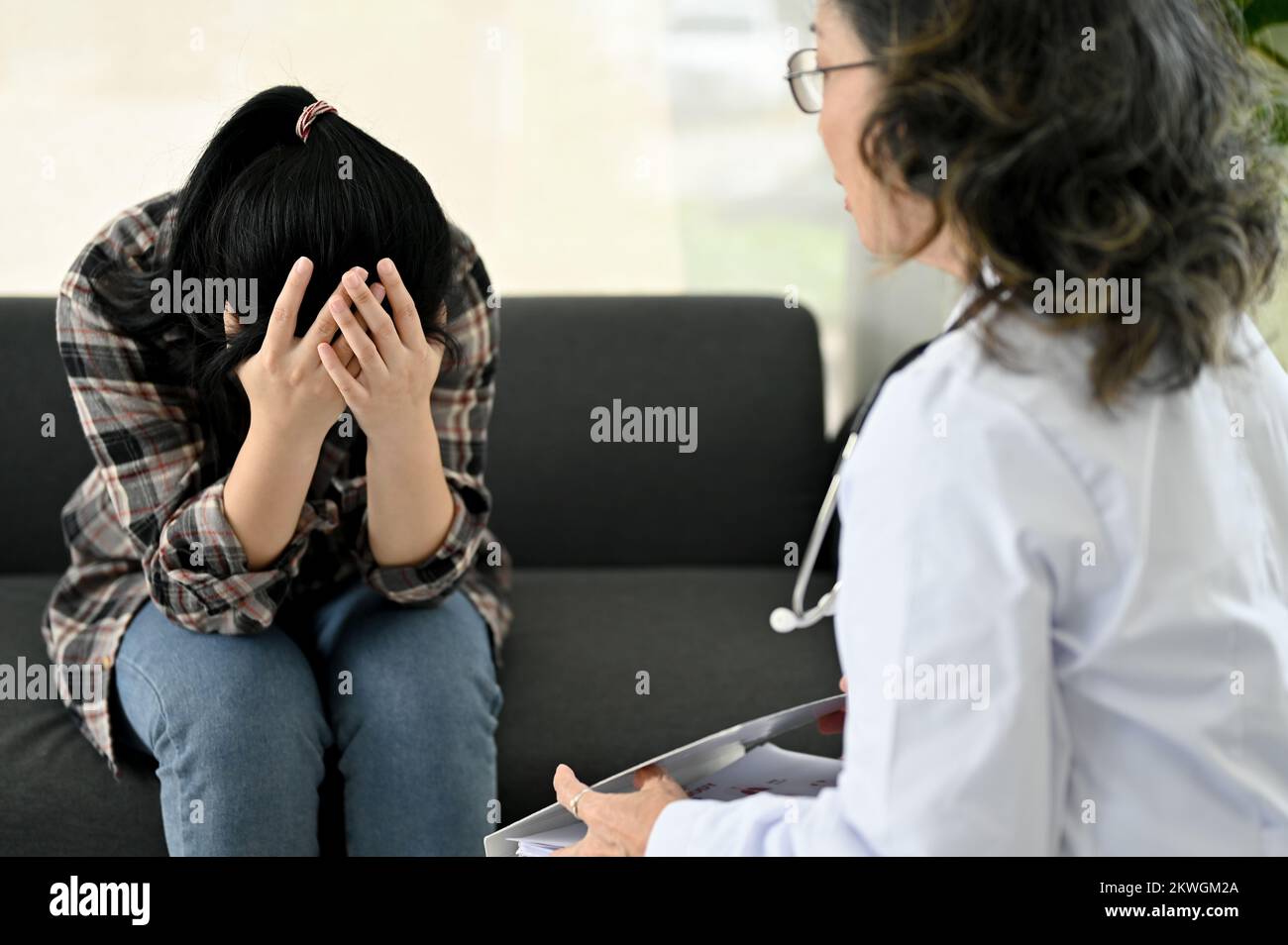 Gestresste und depressive junge Asiatin mit Termin bei ihrem persönlichen Psychiater oder Psychologen in der Klinik. Psychische Gesundheit Problem conce Stockfoto