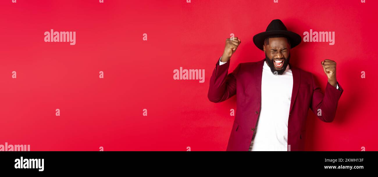 Sagt Man Schwarzer Oder Farbiger Erfolgreicher schwarzer Mann im Anzug, der ja sagt, sich über das