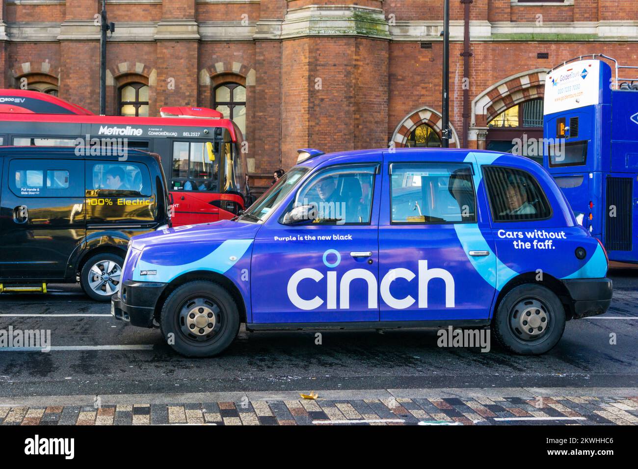 Ein lila schwarzes Londoner Taxi, das für die Online-Gebrauchtwagenhändler Cinch wirbt. Stockfoto