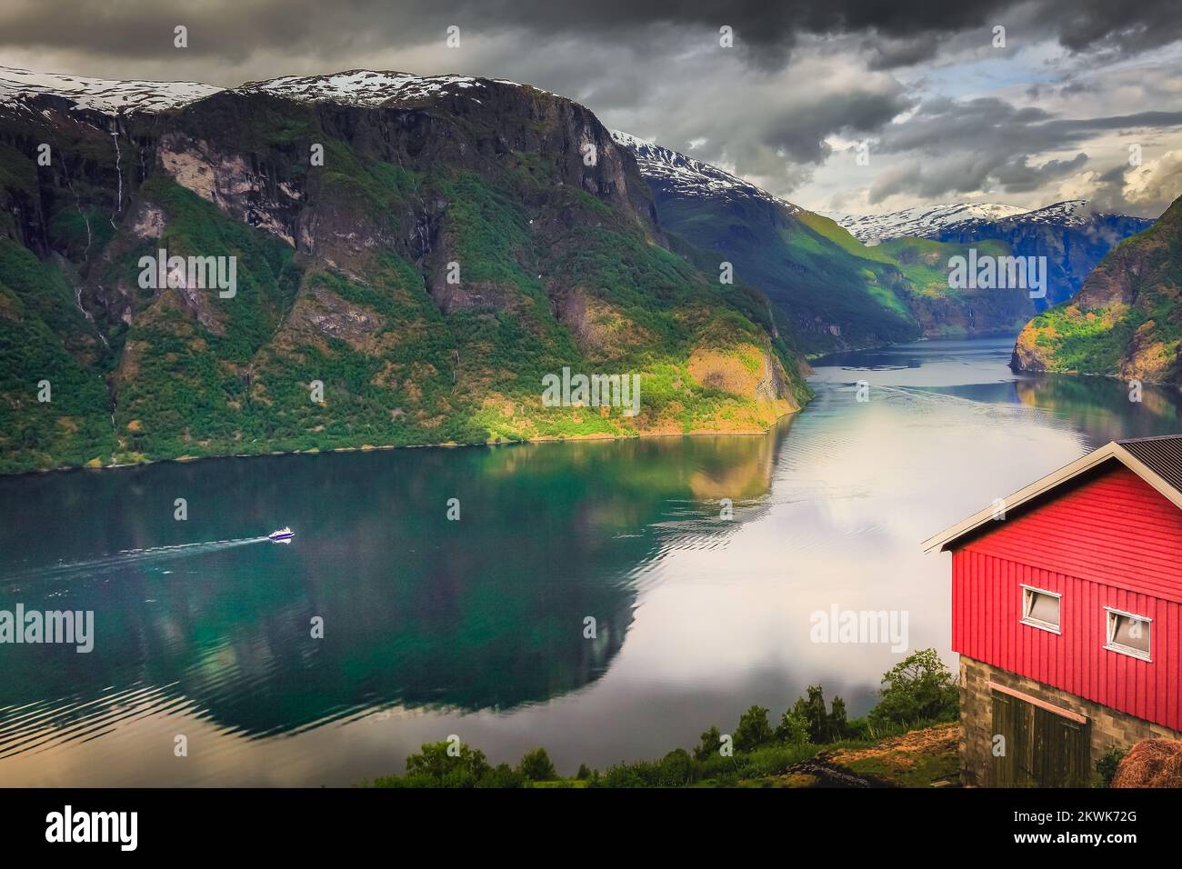 Norwegischer Rorbu über dem Aurlandsfjord mit Reflexion und Boot, Norwegen, Nordisch Stockfoto