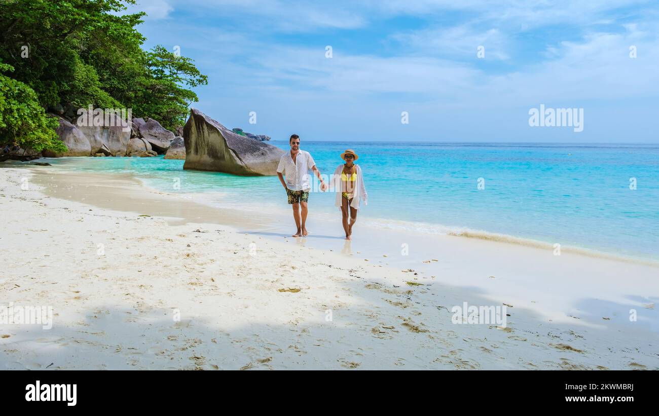 Ein paar Männer und Frauen am tropischen weißen Strand mit türkisfarbenem Ozean der Similan Inseln Thailand. Stockfoto